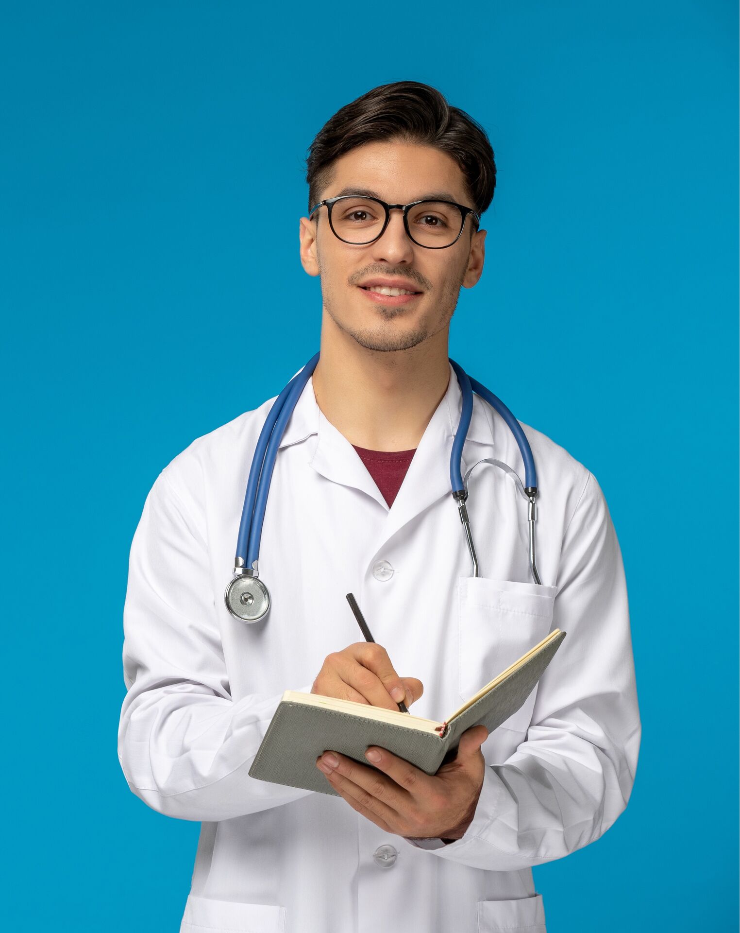 Physician in lab coat writing in a notebook
